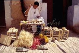 Image du Maroc Professionnelle de  Un artisan marocain fabrique des chaussures, de chapeaux de paille, et de vannerie en raphia, une fabrication artisanale faite main dont la production est très prisée par la population. Son Atelier se situe dans une rue à l'ancienne Kasbah de  Ouarzazate où résident les berbères du sud du Maroc, le Vendredi 22 Août 1997. (Photo / Abdeljalil Bounhar)

 